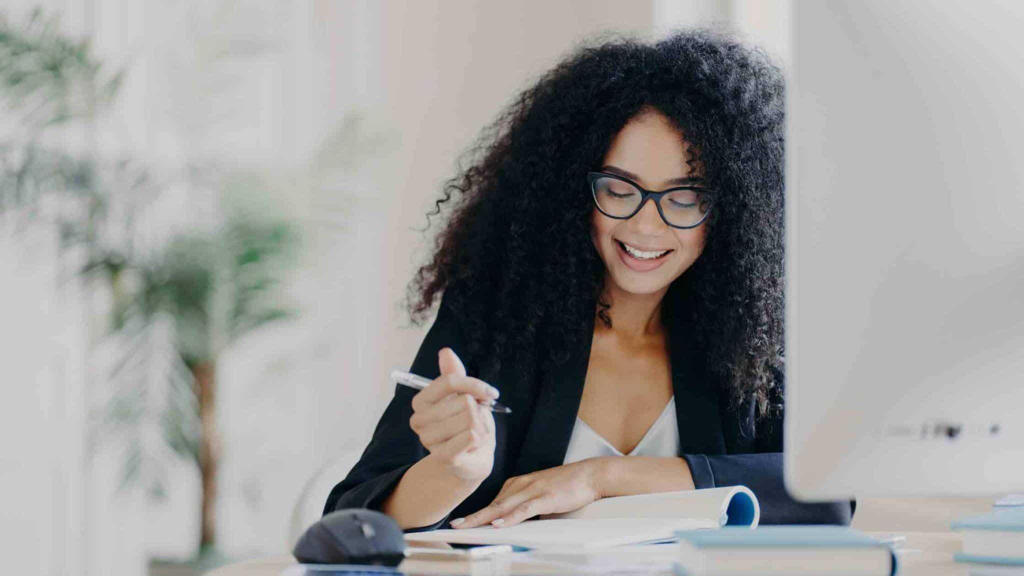 Woman writing in a notebook smiling